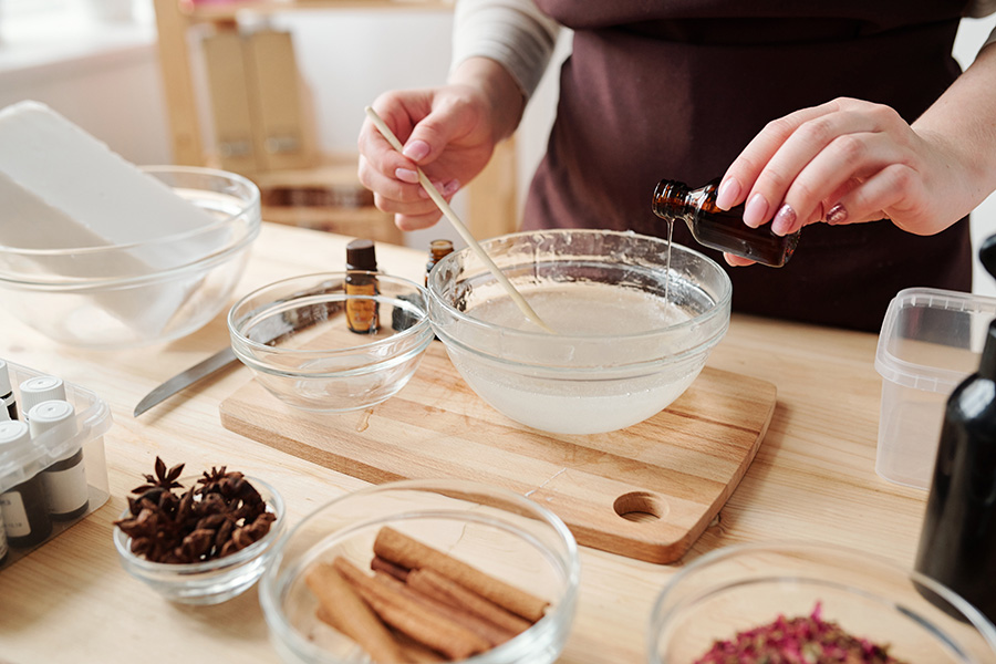 Woman mixing different ingredients into a clear bowl